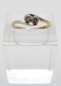An 18ct gold ring set with two diamonds in a platinum crossover setting,