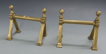 A large pair of Arts and Crafts brass fire dogs with impressed Maltese Cross mark to base