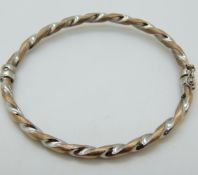 A 9ct bi-coloured gold bangle, 5.