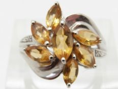 A 9ct white gold ring set with citrine and diamonds in a floral cluster,