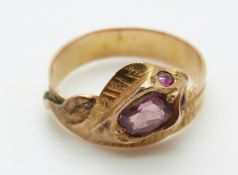 A yellow metal ring in the form of a snake set with an amethyst and ruby eyes,