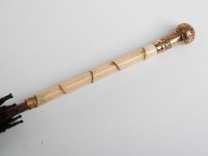 Victorian parasol with 15ct gold repoussé decorated handle with carved ivory and hardwood stick,