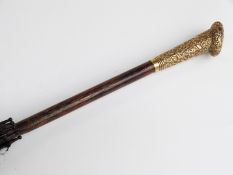 A late 19thC/20thC parasol with yellow metal handle in the form of a heart,