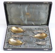 Cased set of three German white metal serving spoons with gilt metal bowls,