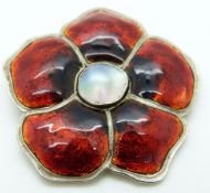 A white metal brooch set with mother of pearl to the centre and red enamel petals, diameter 4.