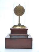 Rebes hand built electric clock under a glass dome, raised on a plinth,