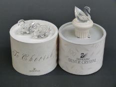 Three Swarovksi Crystal Swans one on a display plinth, largest 7cm long,