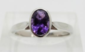 A 9ct white gold ring set with an oval amethyst,