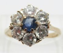 A 9ct gold ring set with a sapphire surrounded by paste,
