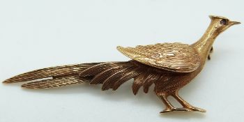 A 9ct gold brooch in the form of a bird set with a garnet eye, 5g, 6 x 2.
