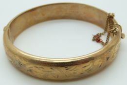 A 9ct gold bangle with engraved foliate decoration, 18.