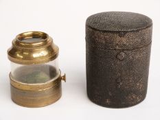 A 19thC taxidermy beetle suspended in a brass magnifier case with knob to turn the beetle,