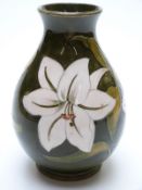 Moorcroft vase decorated with lilies on a green ground, signed to base,