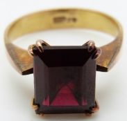 A 9ct gold ring set with an emerald cut garnet,