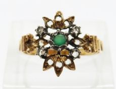 A yellow metal ring set with an emerald and white sapphires,