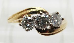 An 18ct gold ring set with three round cut diamonds, the centre diamond approximately 0.
