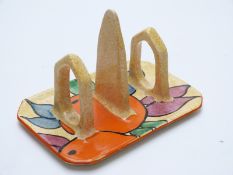A Clarice Cliff Newport Pottery Bizarre two-division toast rack decorated with oranges,