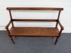 A 19thC oak settle with bevelled upright and frame raised on turned legs W122cm, D38cm,