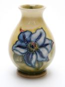 Moorcroft pedestal vase in Clematis pattern on a yellow ground,
