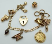 A 9ct gold charm bracelet with various 9ct gold/ yellow metal charms including a heart padlock,