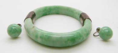 A jadeite bangle with white metal fittings and jadeite earrings with silver fittings