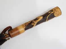 A 19thC/20thC parasol with faux ivory handle on hardwood stick,