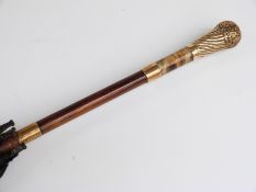 A late 19thC/20thC parasol with 18ct gold plated handle and two collars,