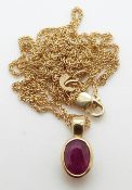 A 9ct gold pendant set with an oval ruby on a 9ct gold chain, 3.