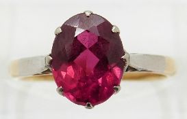 An 18ct gold ring set with an oval cut synthetic ruby,