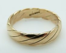 A 9ct gold wedding band in a twist design, size V, 5.