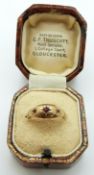 A 9ct gold ring set with three garnets in Gloucester box,