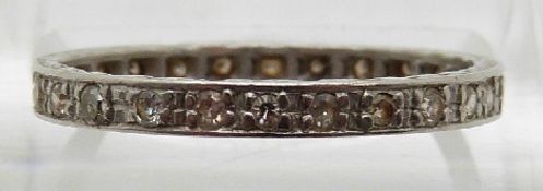 A platinum eternity ring set with diamonds and engraved sides,