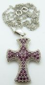 A 9ct white gold cross set with rubies and diamonds on a 9ct gold chain, 7.