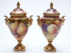 Coalport pair of pedestal lidded urns decorated with fruit, signed A G Budd and J Mottram,