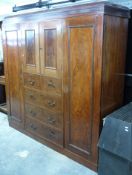 19thC or early 20thC compactum with cupboard above two over three drawers flanked by wardrobes,