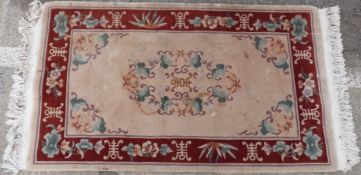Chinese style rug with geometric decoration on cream ground together with a florally decorated rug