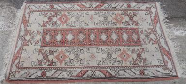 Three similar rugs all with geometric decoration of burnt orange ground,