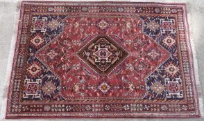 Khamseh style rug with central Qashqa type medallion and all over geometric decoration on a red