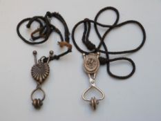 Two Victorian skirt lifters with cord,