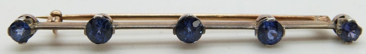 A 9ct gold brooch set with five round sapphires with a platinum finish