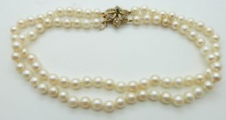 A double strand pearl necklace with 9ct gold clasp set with a sapphire and diamonds
