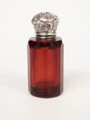 A 19th/early 20thC white metal lidded ruby glass scent bottle with faceted body, height 6.5cm