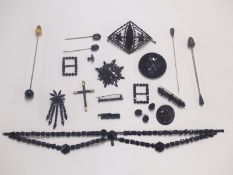 A collection of jet jewellery including brooches, Victorian stick pin set with a pearl, buckles,
