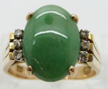 A 14ct gold ring set with a jadeite cabochon and six diamonds, size O
