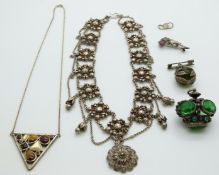 A silver necklace set with tiger's eye and mother of pearl, a silver dolphin brooch set with rubies,