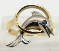 A 14ct gold ring in the form of a dolphin set with a sapphire eye, size L