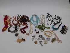 A collection of costume jewellery including brooches, beaded necklaces, silver and agate necklace