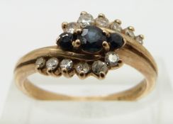 A 9ct gold ring set with sapphires and diamonds in a twist setting, size O