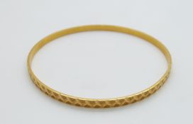 A 22ct gold bangle with cut out and textured detail, 12.5g