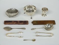 A quantity of hallmarked silver items including sugar bowl, tea strainer, egg cups, sugar tongs